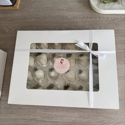 A window gift box of white chocolate strawberries tied with white ribbon.