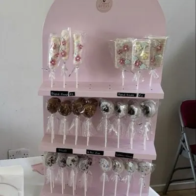A pink display stand of cake pops and treats.