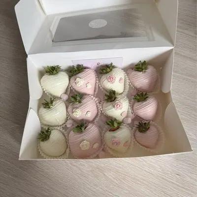 Pink and white chocolate strawberries decorated with hearts.