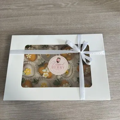 A window gift box of floral chocolate strawberries tied with ribbon.